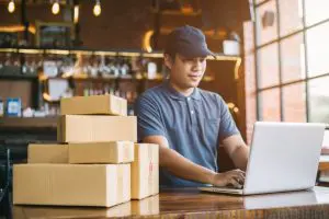 ecommerce business packaging on laptop as owner works from desk