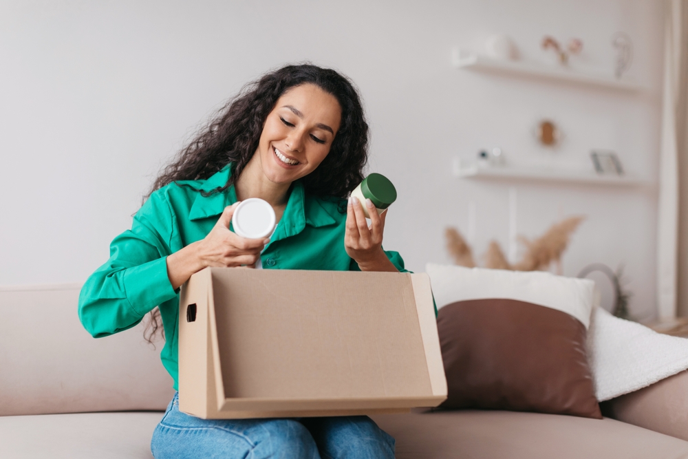 Smiling customer holding a box with cosmetic products