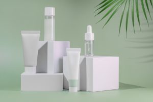 White cosmetics packaging on green background