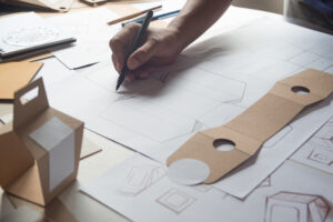 Designer creates sketch from custom boxes with logo