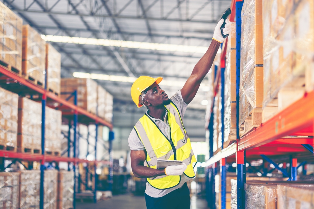 Warehouse worker checks shelves of industrial packaging