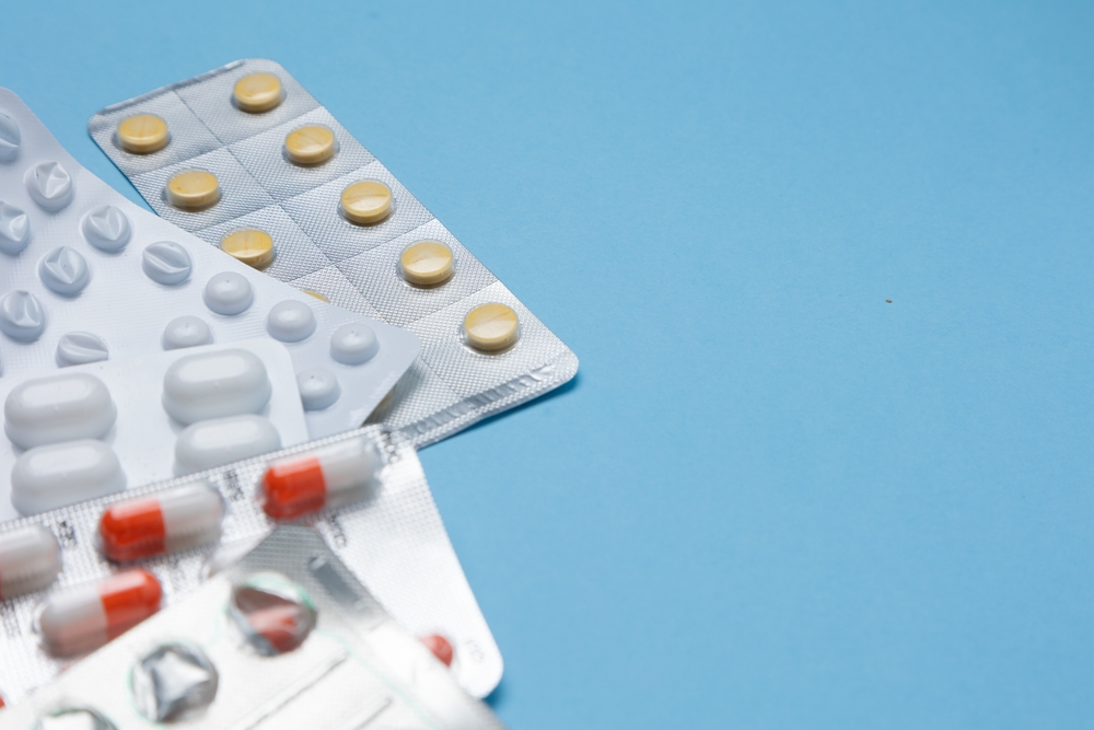 Assorted pharmaceutical blister packaging on a blue background